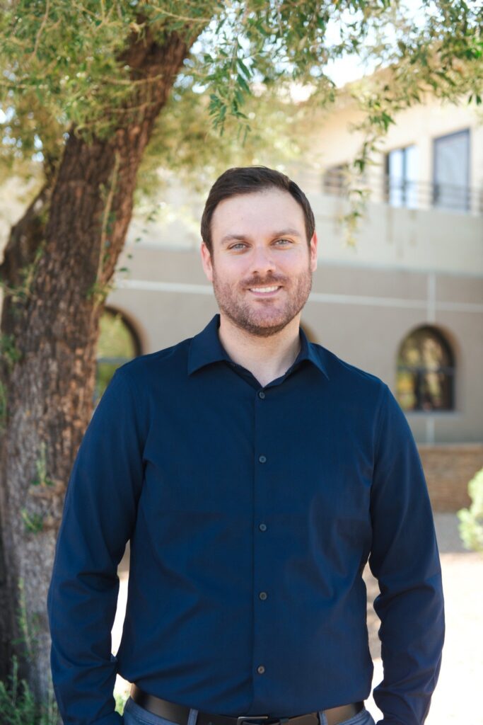 Therapist Michael Tugendhat standing outside in a blue sweater.