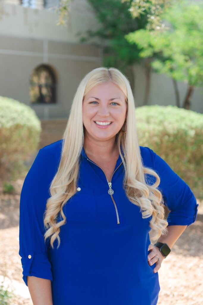 Therapist Tara Verhagen standing outside in a blue sweater.